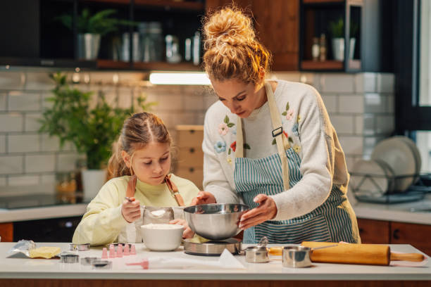 istock Mother and daughter baking together in modern kitchen 2204991220