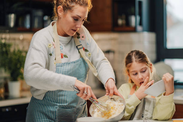 istock Mother and daughter baking a cake together in the kitchen 2204991251