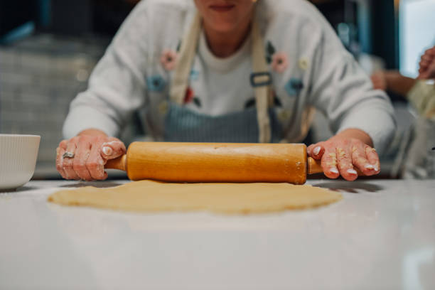 istock Woman using rolling pin making cookies in the kitchen 2204991281