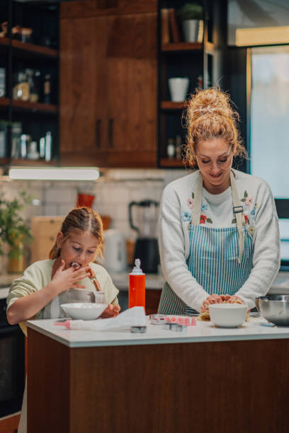 istock Mother and daughter baking cookies in modern kitchen 2204991283
