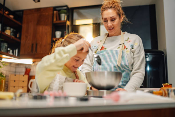 istock Mother and daughter baking together in modern kitchen 2204991299