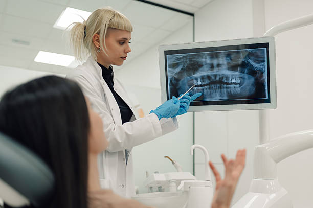istock Dentist showing teeth x-ray to patient in modern clinic 2204991365