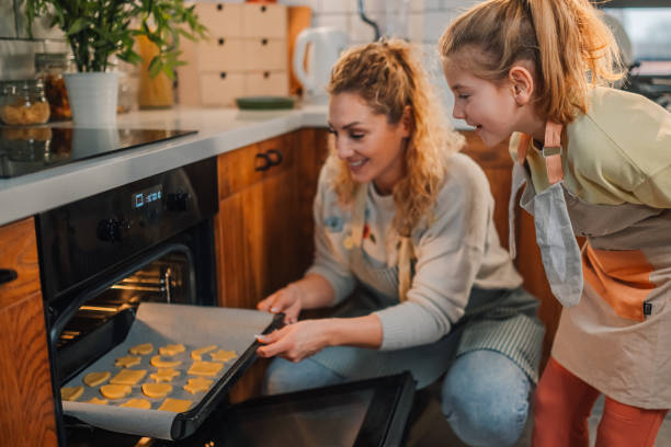 istock Mother and daughter baking cookies in modern kitchen 2204991425