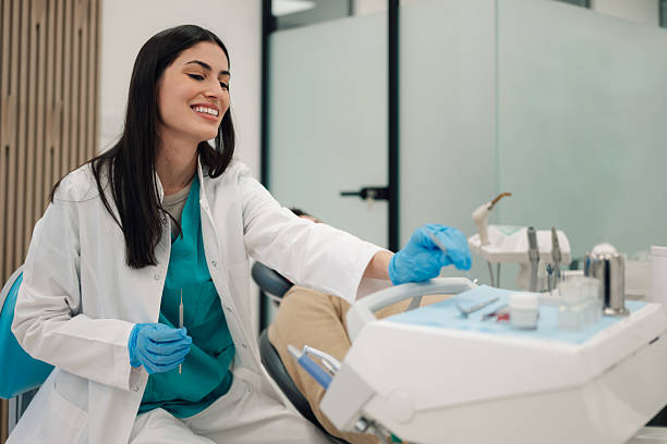 istock Female dentist picking up tools preparing for patient examination 2204991471