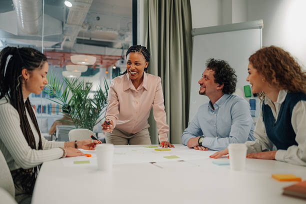 istock Diverse business team brainstorming around a table, sharing ideas and smiling 2204991547