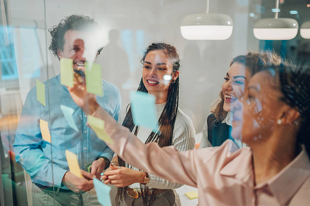 istock Business team brainstorming and planning with sticky notes on glass wall in office 2204991676
