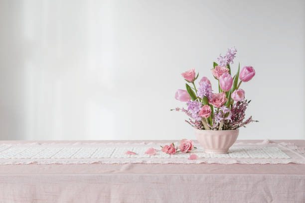 istock pink flowers in vase on background white wall 2204992229
