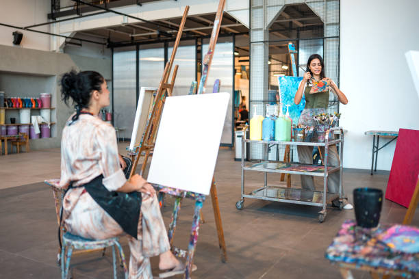 istock Young Middle Eastern Art Teacher Guiding Students in a Bright Studio with Vibrant Canvas and Tools 2204993709