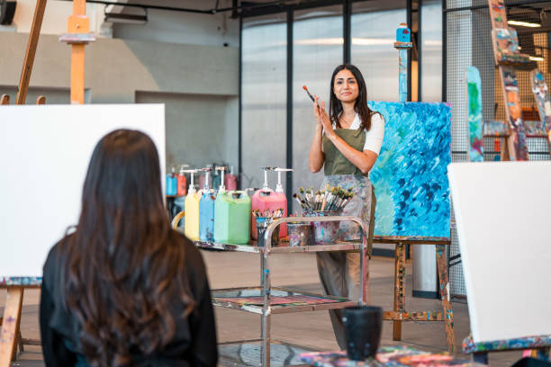 istock Confident Middle Eastern Art Teacher Guiding Students in a Bright Modern Studio 2204993754