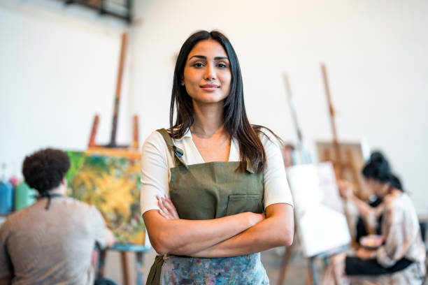 istock Confident Young Middle Eastern Art Teacher in Studio with Students and Creative Artwork 2204993799