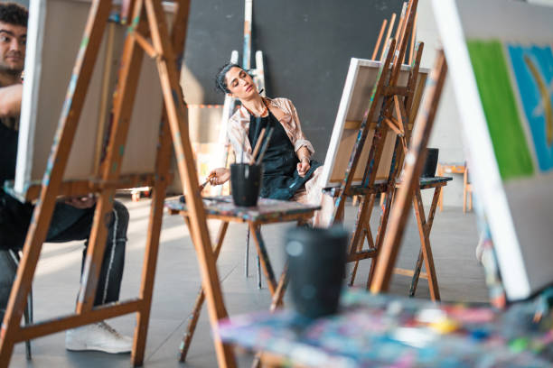 istock Young Middle Eastern Female Artist Painting at a Modern Art Studio with Focused Expression 2204993809