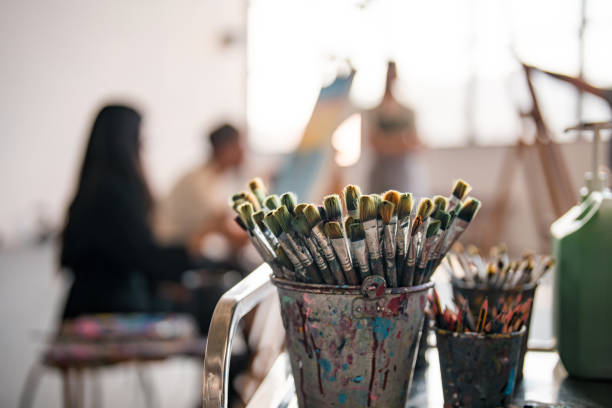 istock Art Class Painting Brushes in Sunlit Studio with Diverse Students 2204993878
