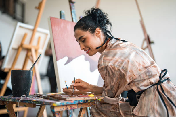 istock Young Middle Eastern Female Artist Painting in a Bright Studio with Natural Light 2204993896