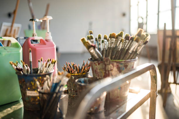istock Sunlit Art Studio With Paint Brushes And Creative Supplies In Glass Jars 2204993929