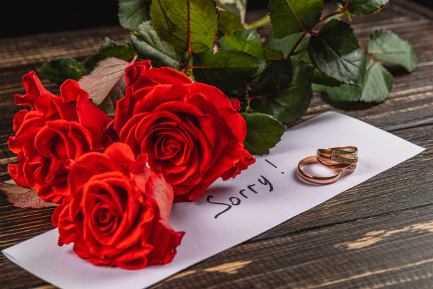 istock Emotional farewell with red roses and a broken engagement ring 2205005947