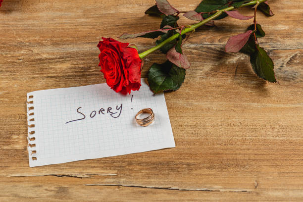 istock Broken engagement with a rose and a note conveying regret and sorrow 2205007010