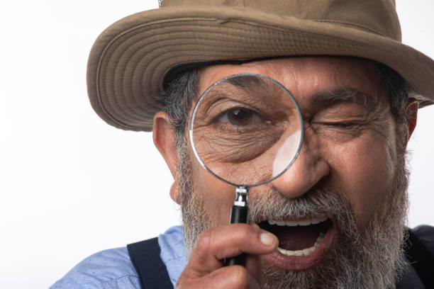 istock Detective looking through magnifying glass on white background 2205011865