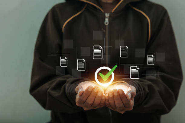 istock A person is holding a glowing green check mark. The check mark is surrounded by several other check marks 2205017024