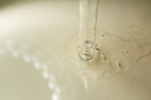 A drop of cosmetic aromatic oil drips from the pipette. Front view.