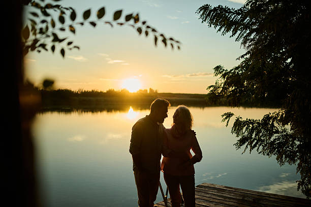 istock Senior couple enjoying sunset over lake 2205019954