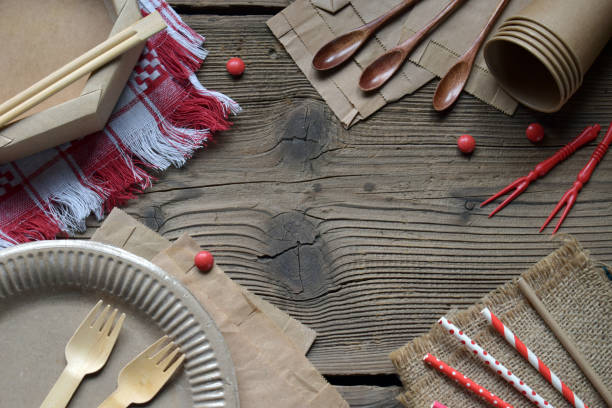 istock Natural Brown Eco Tableware Set on Vintage Wooden Background. Recyclable and Compostable Forks, Spoons, Paper Straws, and Cups for Environmentally Friendly Dining and Takeaway Use 2205022638