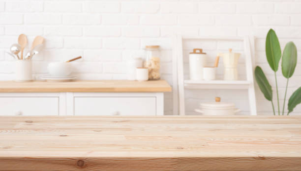 istock Empty wooden table for product display with blurred bright white interior of kitchen as background 2205022925