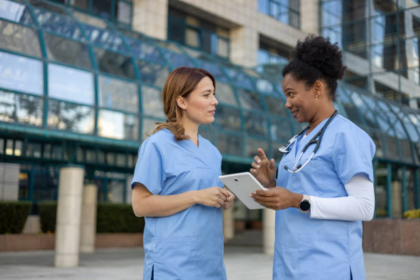 istock Two nurses discussing patient information using digital tablet outside hospital 2205023239