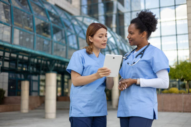 istock Two nurses consulting a digital tablet outside the hospital 2205023258