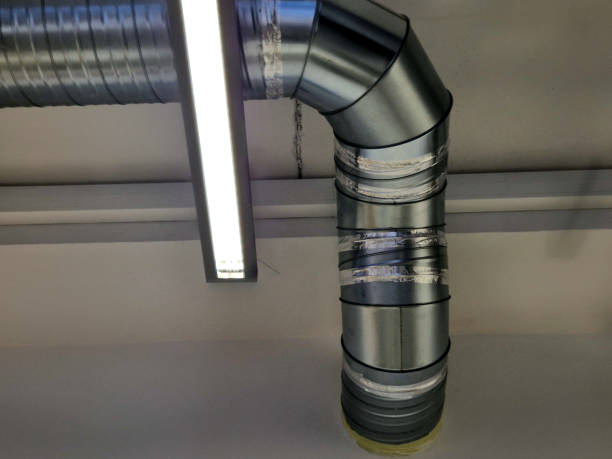 istock New air conditioning ductwork is visible in an industrial hall with overhead lighting hanging in strips from the ceiling. silver sheet metal 2205024531