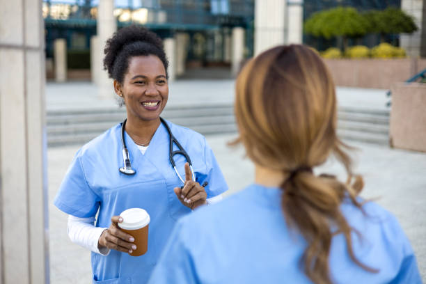 istock Two nurses talking during coffee break outside hospital 2205025484