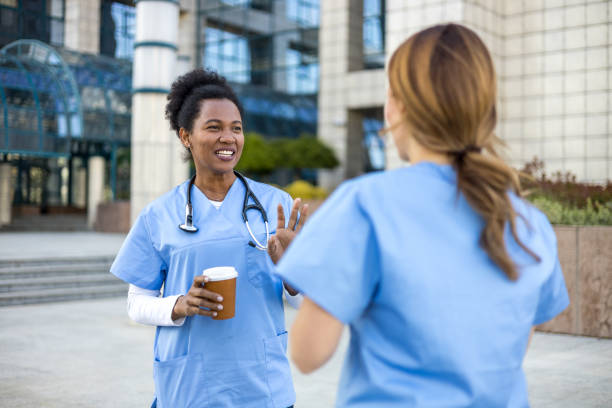 istock Two nurses talking during coffee break outside hospital 2205025594
