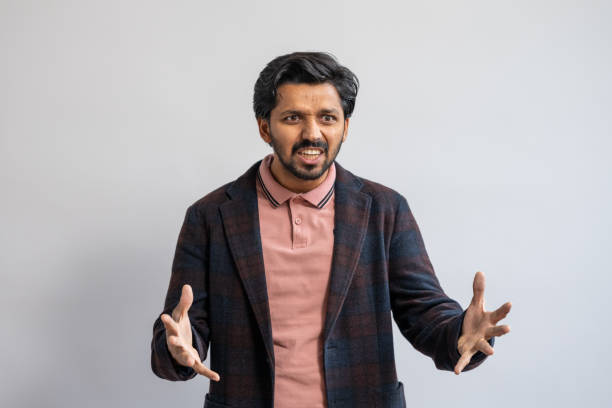 istock Expressive Indian Male in Dark Blazer Against Neutral Backdrop 2205028201