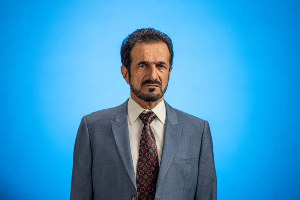 Happy young man. Portrait of handsome young man in casual shirt keeping arms crossed and smiling while standing against grey background