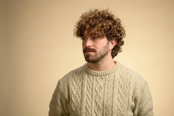 istock Young Hispanic Man in Beige Sweater Studio Portrait 2205028249