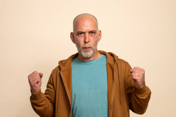 istock Determined Man in Teal Shirt Showing Intense Expression Against Beige Background 2205028267