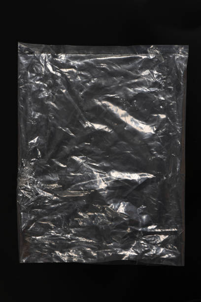 istock Polyethylene bag on a black background. Transparent plastic wrap on the black background. Clean blank texture overlay effect template. 2205028915