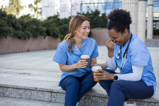 istock Two nurses laughing together during coffee break outside hospital 2205029988