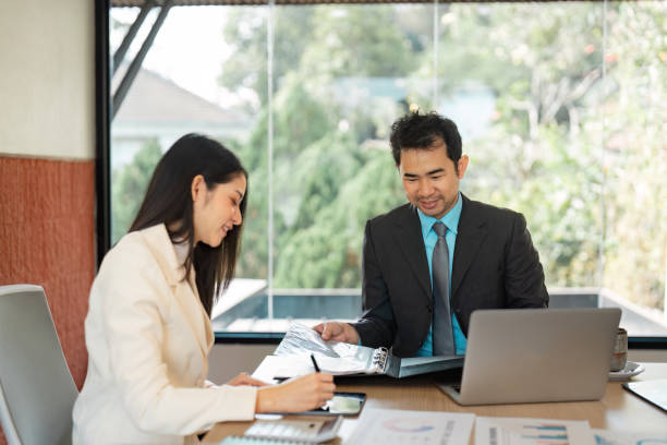 istock Business professionals discussing project strategies with documents and a laptop in a collaborative workspace. 2205030012