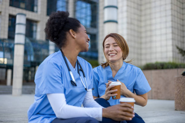 istock Two nurses laughing together during coffee break outside hospital 2205030037