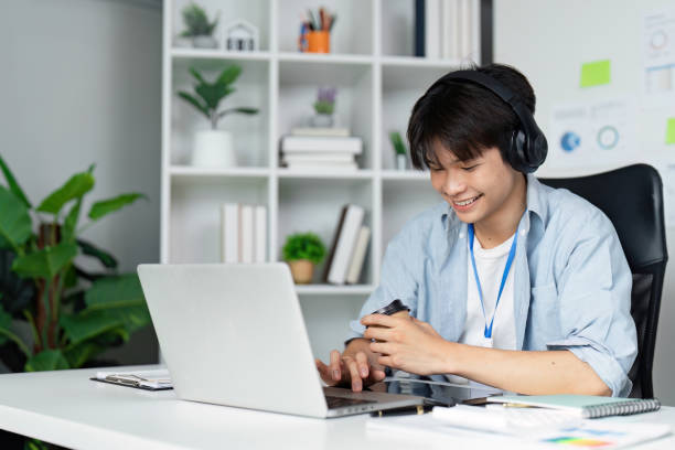istock Young business professional focused on work while sipping coffee and using a laptop in a modern office. 2205031276
