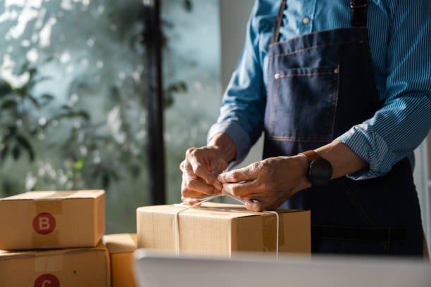 istock Entrepreneur packing boxes for online business shipment, showcasing startup logistics and efficiency. 2205034457