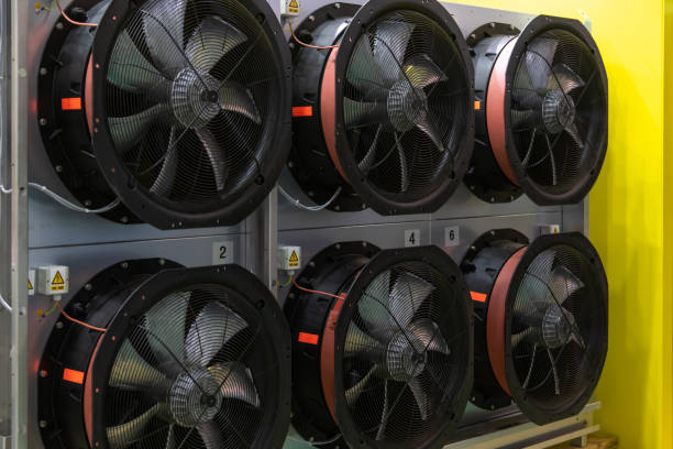 Several large industrial fans are mounted on a wall in a facility. These fans are designed for cooling and ventilation, enhancing air circulation in the space.
