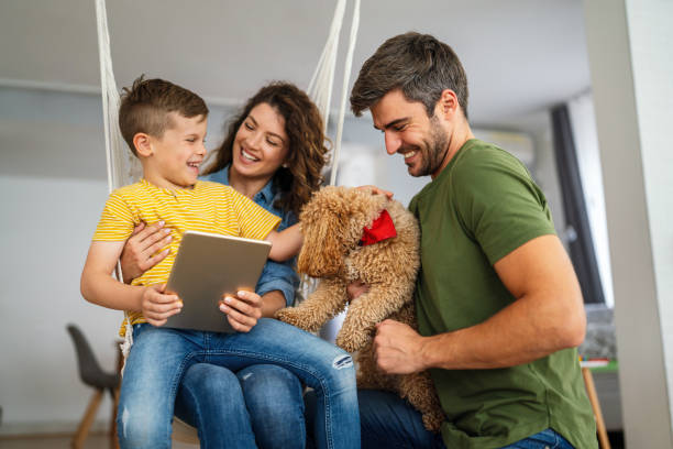 istock Parents and child relaxing at home with computer watching funny internet video, making online call 2205035250