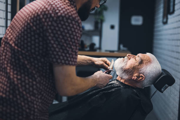 istock Senior man cutting his beard in barbershop 2205036201