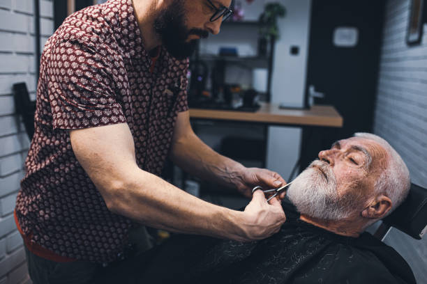 istock Senior man cutting his beard in barbershop 2205036274