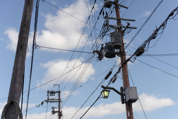 istock Electric pole with connected wires against a blue sky. 2205038007