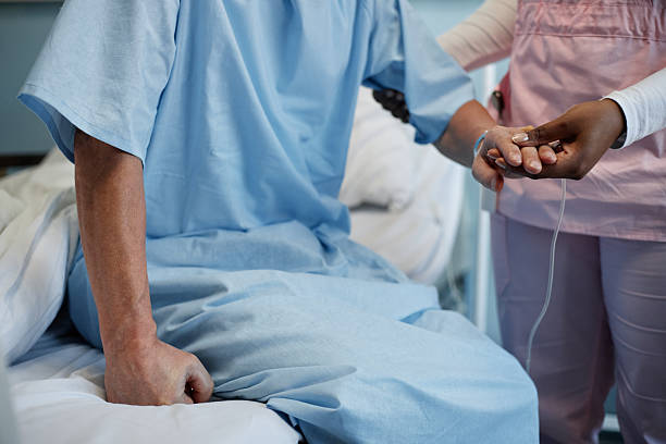 istock Hospital Worker Comforting Seated Patient Clasping Hands 2205039141