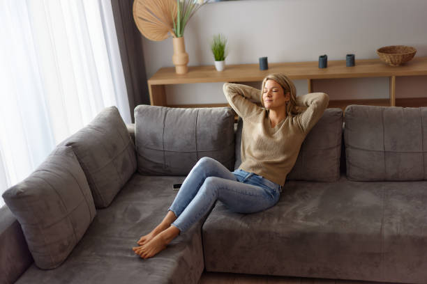 istock Relaxed woman enjoying on sofa at home. 2205042382