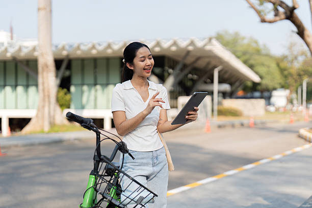 istock Sustainable Transportation and Digital Communication. A person checking their tablet while enjoying the outdoors with a bicycle. 2205043989