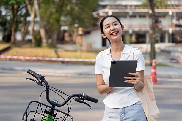 istock Sustainable Living and Technology. A woman engaging with her tablet while stopped on her bicycle. 2205044239